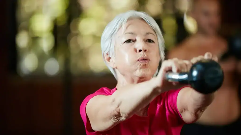 Older woman doing weight training Melton Mowbray to help her strength and longevity 