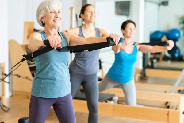 Toning Arms After 60: Empowering Womens Fitness Through Effective Weight Training 2 older woman doing weight training Melton Mowbray and resistance in the gym to tone upper arms
