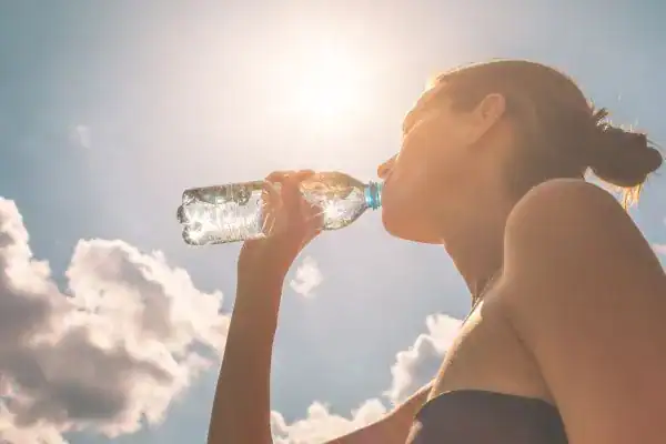 Hydration: The Secret Ingredient for a Toned Stomach and Enhanced Fitness 3 Image of woman drinking water to hydrate Melton Mowbray after run.